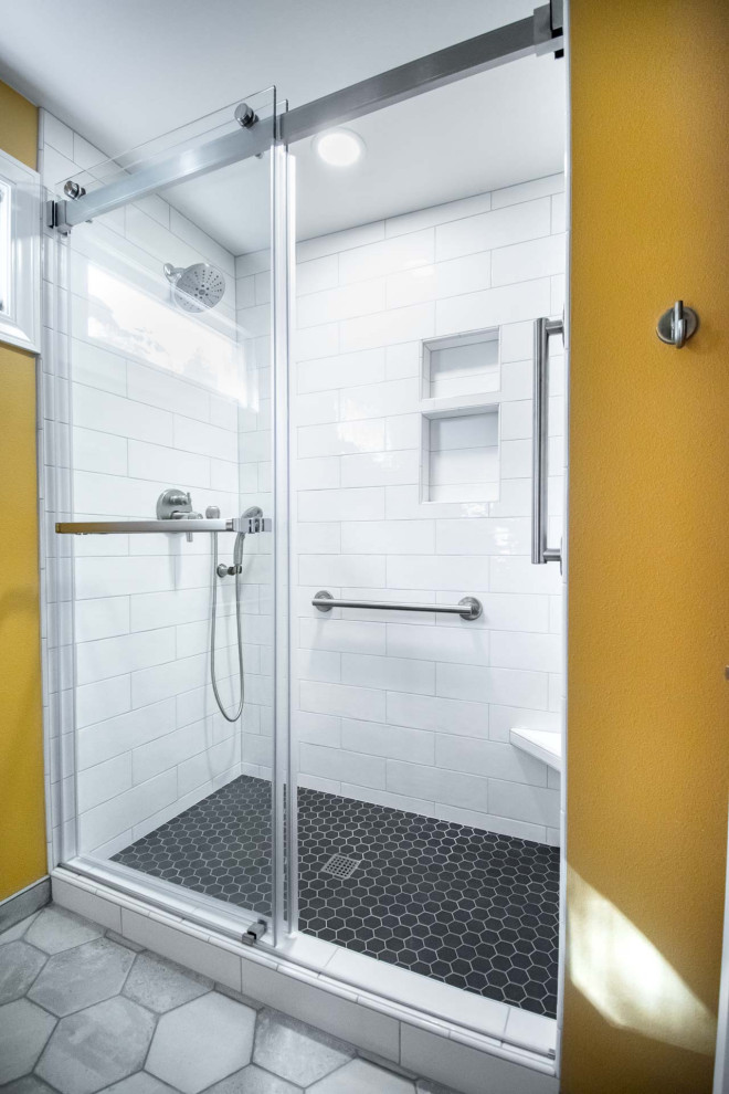 Inredning av ett klassiskt mellanstort grå grått badrum med dusch, med släta luckor, skåp i ljust trä, en dusch i en alkov, en toalettstol med separat cisternkåpa, vit kakel, tunnelbanekakel, orange väggar, klinkergolv i keramik, ett undermonterad handfat, bänkskiva i kvarts, grått golv och dusch med skjutdörr