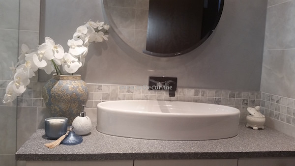 Modern inredning av ett mellanstort badrum, med ett integrerad handfat, möbel-liknande, bänkskiva i kvarts, en kantlös dusch, en toalettstol med hel cisternkåpa, grå kakel, keramikplattor, grå väggar och marmorgolv