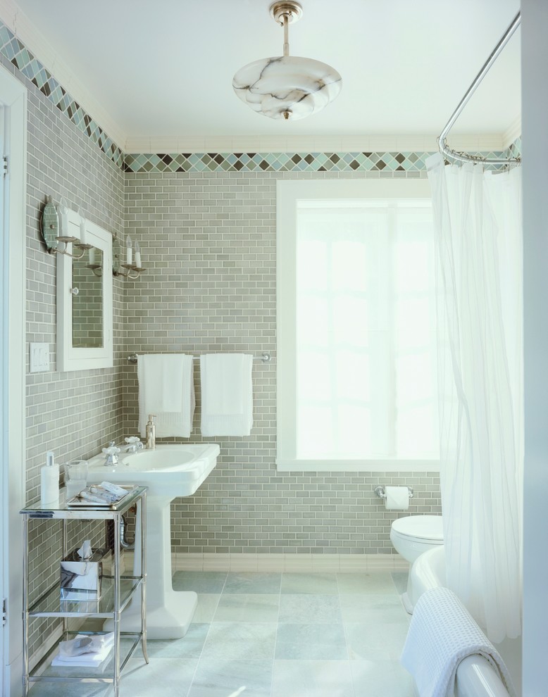 На фото: ванная комната в классическом стиле с раковиной с пьедесталом, душем над ванной, серой плиткой и шторкой для ванной