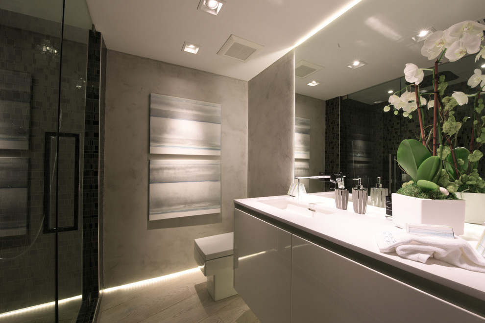 Modelo de cuarto de baño moderno de tamaño medio con armarios con paneles lisos, puertas de armario blancas, encimera de cuarzo compacto, ducha doble y sanitario de una pieza
