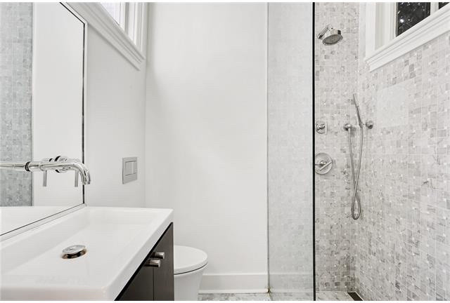 Idéer för ett litet modernt badrum med dusch, med en kantlös dusch, släta luckor, skåp i mörkt trä, en vägghängd toalettstol, grå kakel, marmorkakel, vita väggar, marmorgolv, ett integrerad handfat, grått golv och med dusch som är öppen
