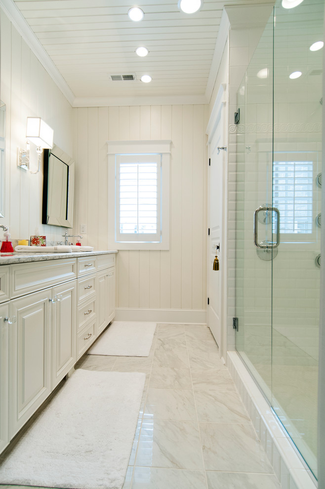 Medium sized traditional ensuite bathroom in Raleigh with a submerged sink, freestanding cabinets, white cabinets, a walk-in shower, white tiles, stone slabs, white walls, marble flooring and marble worktops.