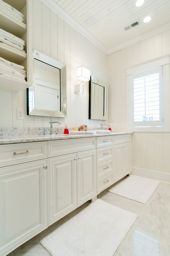 Mid-sized beach style master white tile and stone slab marble floor doorless shower photo in Raleigh with an undermount sink, furniture-like cabinets, white cabinets, white walls and marble countertops