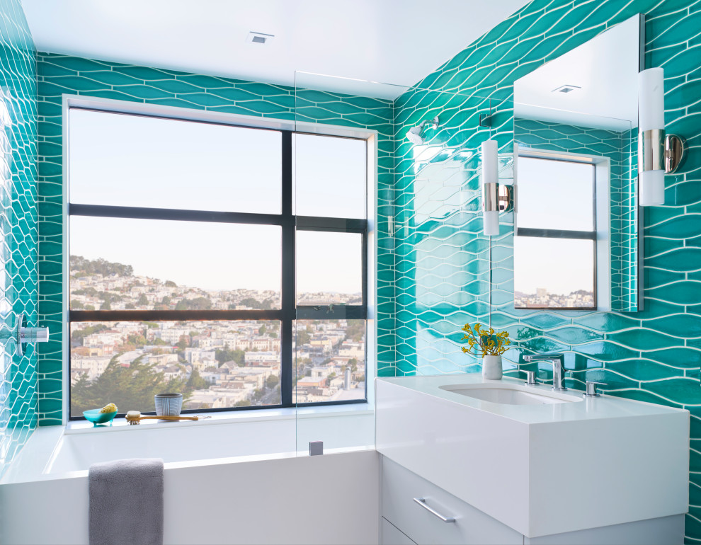 Modernes Badezimmer mit flächenbündigen Schrankfronten, weißen Schränken, Unterbauwanne, Duschbadewanne, blauen Fliesen, Unterbauwaschbecken, weißer Waschtischplatte und Einzelwaschbecken in San Francisco
