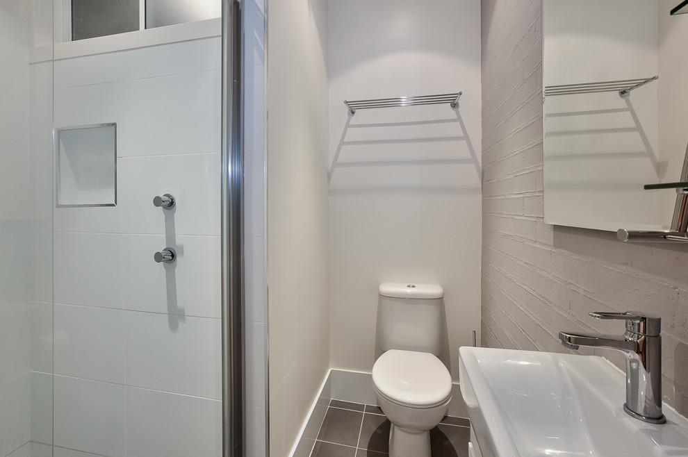 Medium sized contemporary bathroom in Sydney with flat-panel cabinets, white cabinets, an alcove shower, a two-piece toilet, white walls, ceramic flooring, an integrated sink, solid surface worktops, brown floors, an open shower and white worktops.