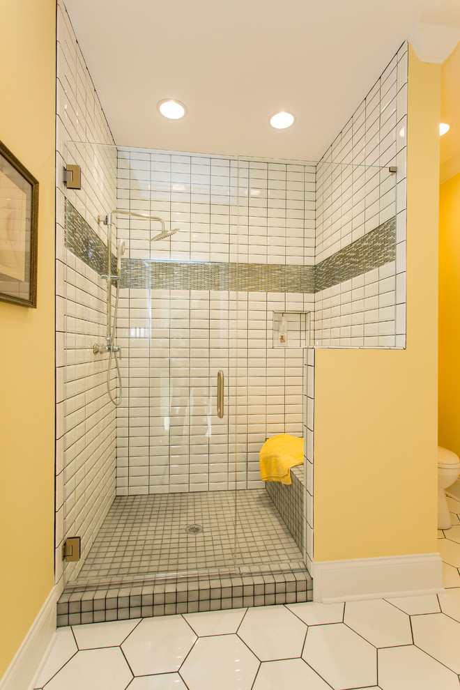 Foto på ett stort funkis badrum, med vita skåp, ett fristående badkar, en hörndusch, en toalettstol med hel cisternkåpa, vit kakel, gula väggar, ett fristående handfat och klinkergolv i keramik