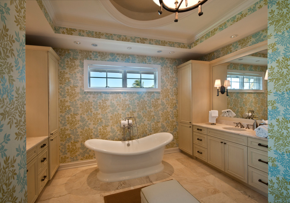 Cette image montre une salle de bain traditionnelle avec un lavabo encastré, un placard avec porte à panneau encastré, des portes de placard beiges et une baignoire indépendante.