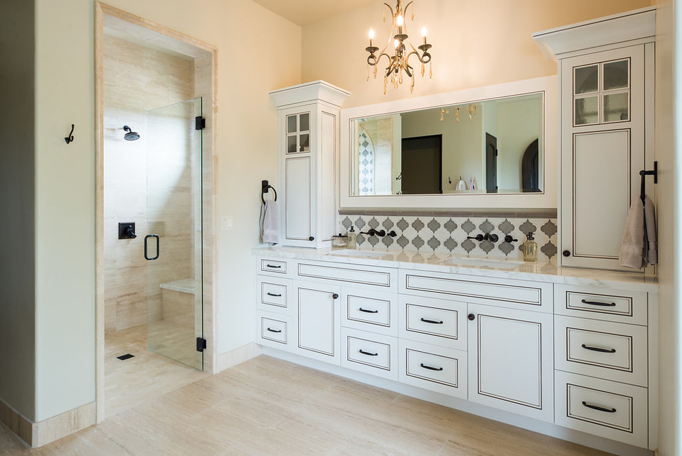 Medelhavsstil inredning av ett mellanstort vit vitt en-suite badrum, med luckor med infälld panel, vita skåp, en dusch i en alkov, beige kakel, vit kakel, marmorkakel, beige väggar, klinkergolv i porslin, ett undermonterad handfat, marmorbänkskiva, beiget golv och dusch med gångjärnsdörr