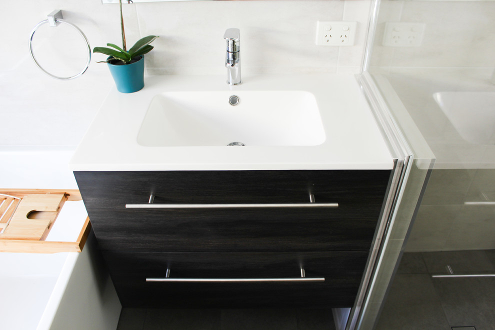 Small family bathroom in Perth with flat-panel cabinets, dark wood cabinets, a freestanding bath, a corner shower, grey tiles, porcelain tiles, grey walls, porcelain flooring, an integrated sink, solid surface worktops, grey floors, a hinged door and white worktops.