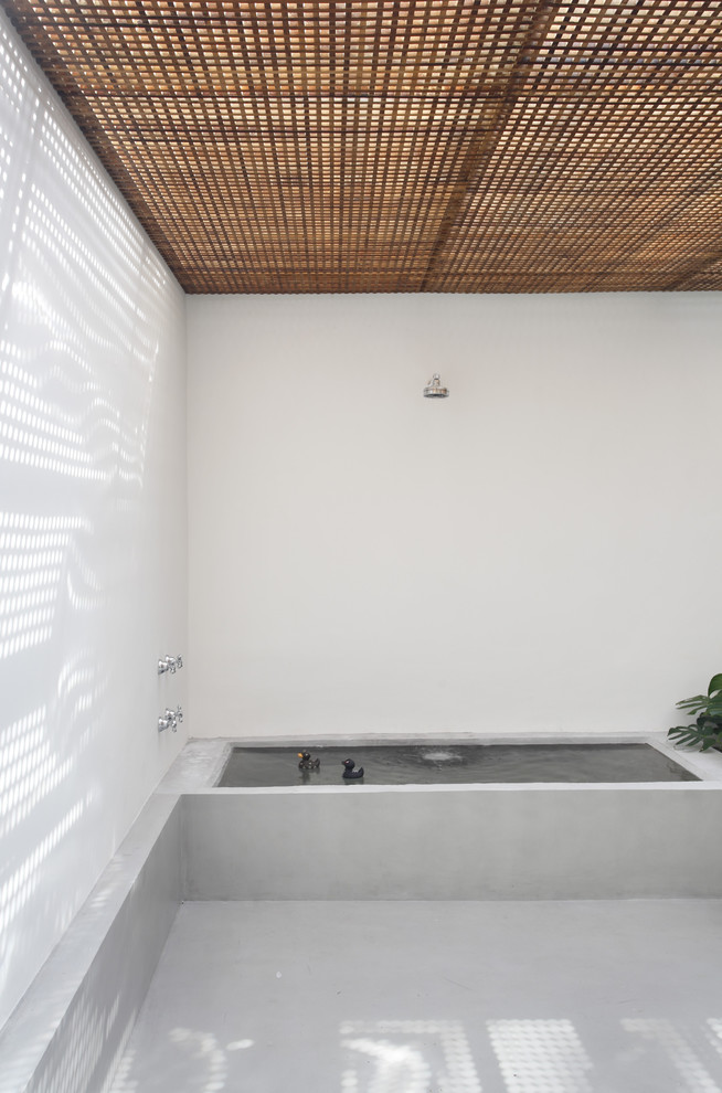 他の地域にあるモダンスタイルのおしゃれな浴室 (アルコーブ型浴槽、グレーのタイル、セメントタイル) の写真