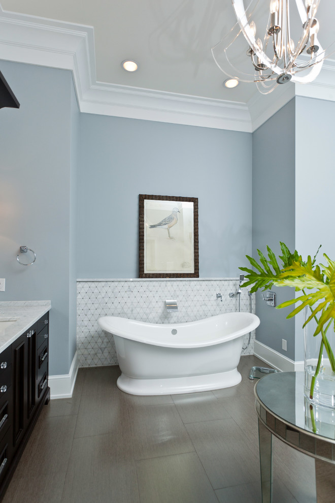 Inspiration for a traditional bathroom in Miami with dark wood cabinets, a freestanding bath and white tiles.