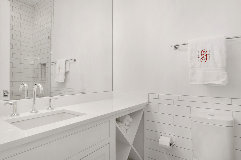 На фото: ванная комната среднего размера в стиле неоклассика (современная классика) с фасадами с декоративным кантом, белыми фасадами, белой плиткой, плиткой кабанчик, белыми стенами, врезной раковиной и столешницей из искусственного камня с