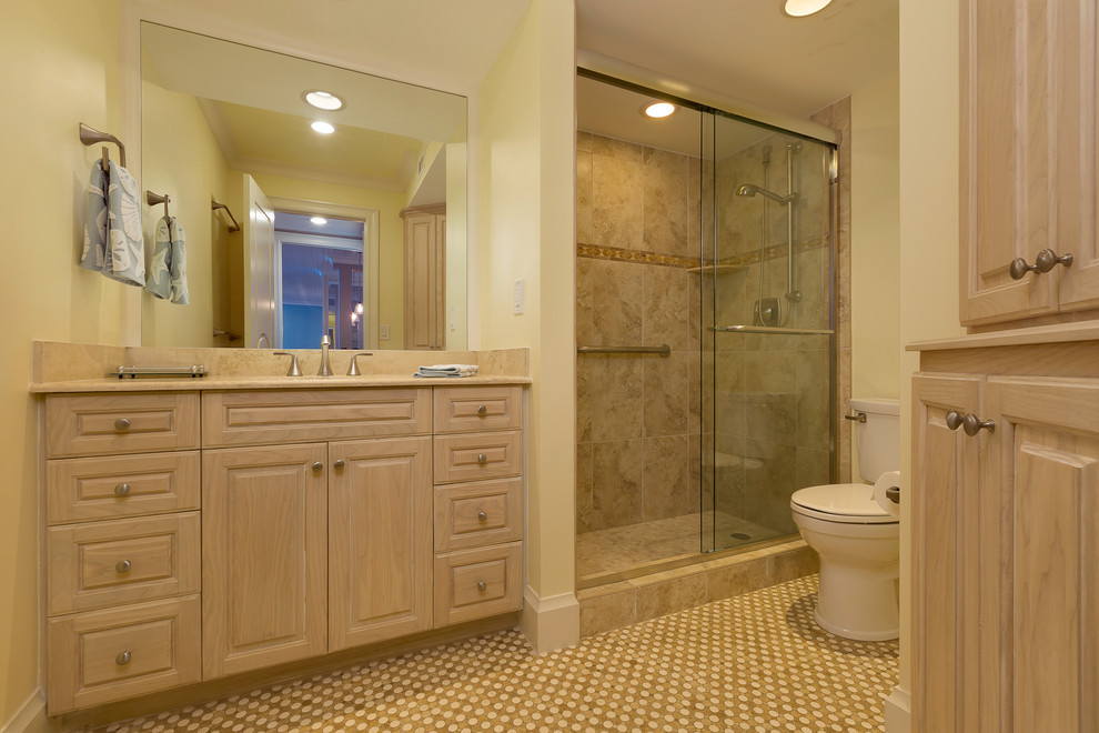 Beach style master multicolored tile and glass tile porcelain tile alcove shower photo in Miami with raised-panel cabinets, light wood cabinets, a one-piece toilet, yellow walls, a drop-in sink and marble countertops