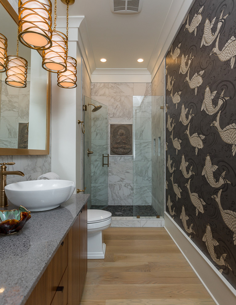 Foto på ett stort maritimt en-suite badrum, med släta luckor, skåp i mellenmörkt trä, en dusch i en alkov, en toalettstol med hel cisternkåpa, flerfärgade väggar, ljust trägolv och marmorbänkskiva