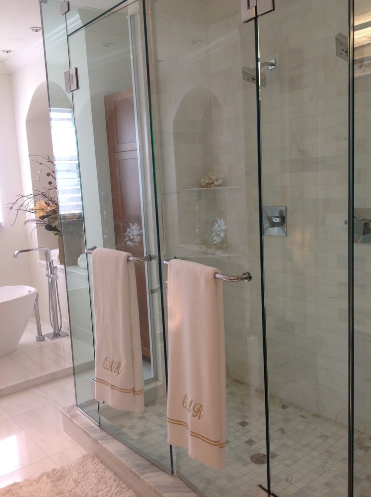 This is an example of a large classic ensuite bathroom in Miami with shaker cabinets, medium wood cabinets, marble worktops, a freestanding bath, a double shower, stone tiles, white walls, marble flooring, a submerged sink and white tiles.