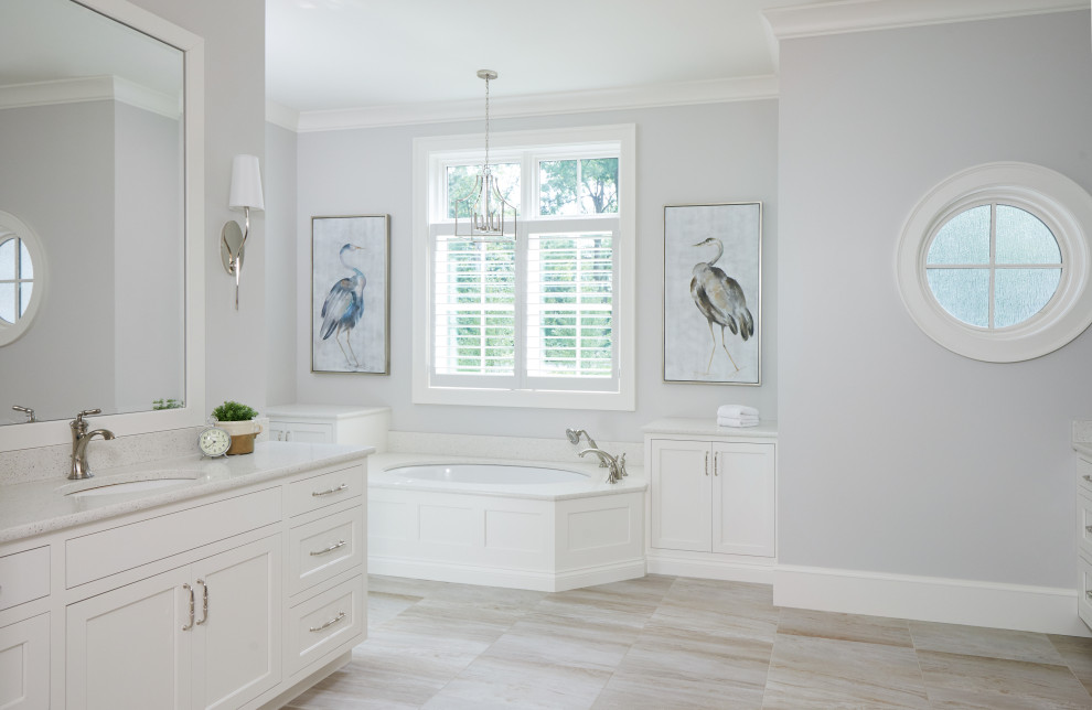 Inspiration for a large traditional ensuite bathroom in Grand Rapids with white cabinets, a submerged bath, grey tiles, grey walls, ceramic flooring, a submerged sink, engineered stone worktops, beige floors, white worktops, double sinks, a built in vanity unit and flat-panel cabinets.