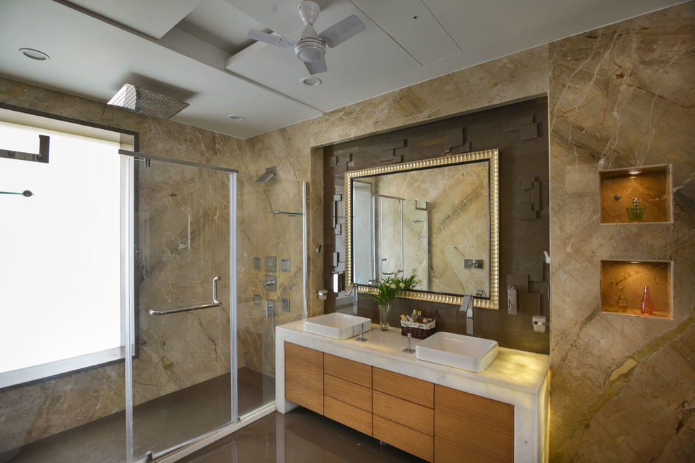 Modernes Badezimmer mit flächenbündigen Schrankfronten, hellen Holzschränken, Duschnische, Aufsatzwaschbecken und Falttür-Duschabtrennung in Delhi