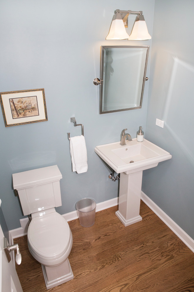 Inspiration för ett litet vintage toalett, med en toalettstol med separat cisternkåpa, blå väggar, mellanmörkt trägolv och ett piedestal handfat