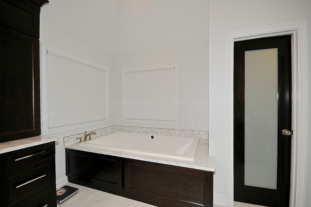 Photo of a contemporary ensuite bathroom in Indianapolis with beaded cabinets, dark wood cabinets, marble worktops, a built-in bath, white tiles, mosaic tiles, grey walls and porcelain flooring.