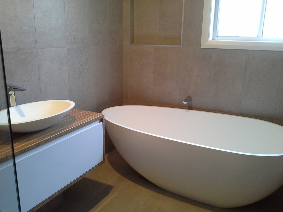 Ispirazione per una stanza da bagno padronale design di medie dimensioni con vasca freestanding, doccia ad angolo, piastrelle di cemento e pavimento in gres porcellanato