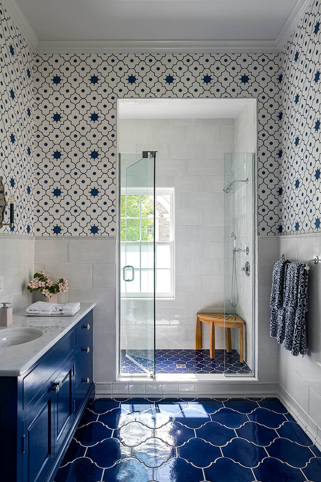 На фото: ванная комната в классическом стиле с фасадами с выступающей филенкой, синими фасадами, душем в нише, белой плиткой, белыми стенами, душевой кабиной, врезной раковиной, синим полом, душем с распашными дверями и белой столешницей с