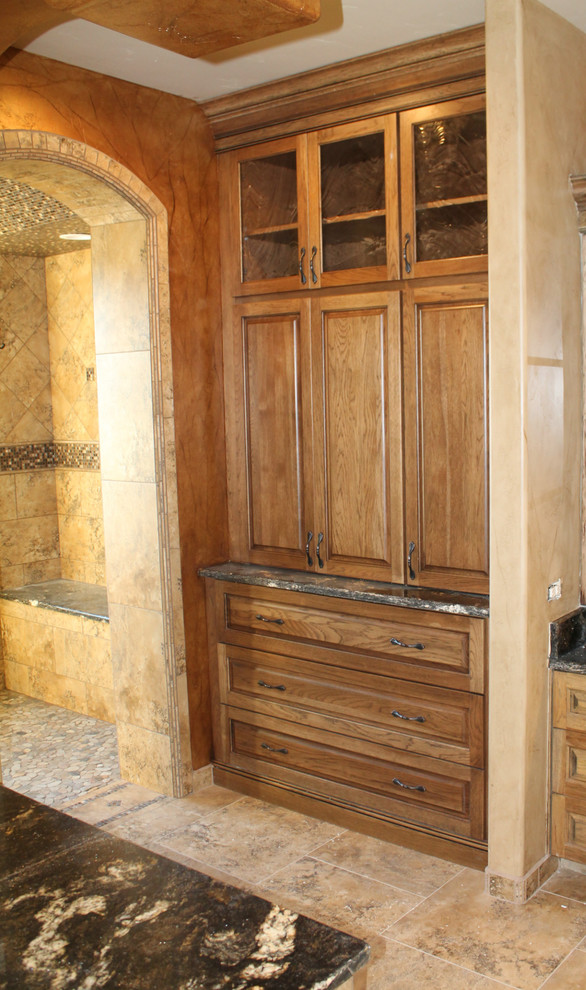 Ejemplo de cuarto de baño principal mediterráneo con armarios con paneles con relieve, puertas de armario de madera oscura, encimera de granito y baldosas y/o azulejos de cerámica