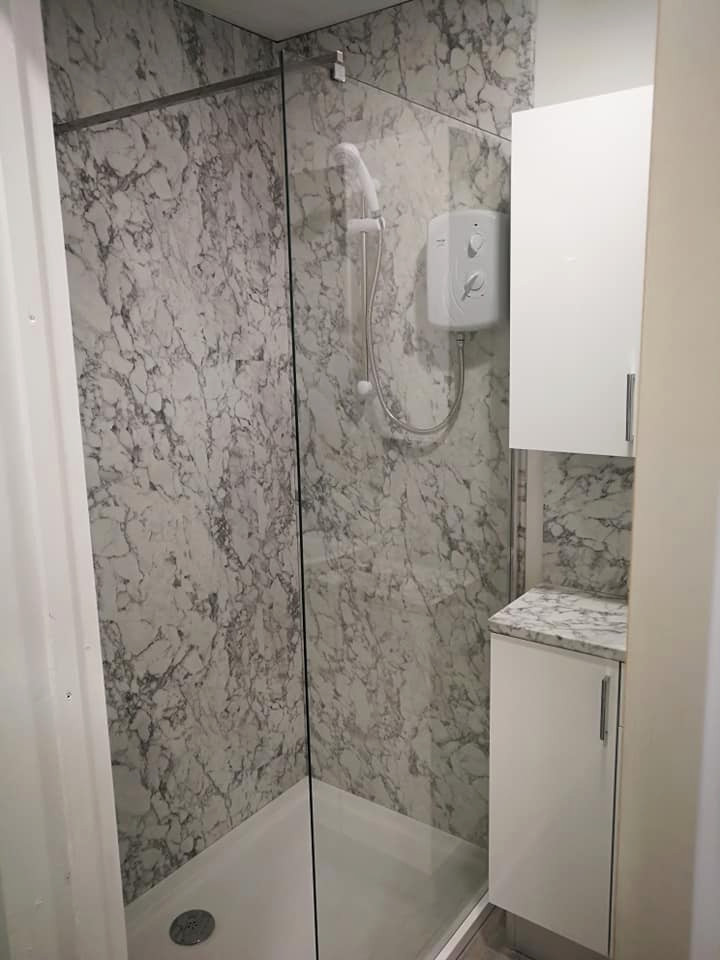 Modern inredning av ett litet grå grått badrum med dusch, med släta luckor, vita skåp, en öppen dusch, en toalettstol med hel cisternkåpa, vita väggar, vinylgolv, ett integrerad handfat, laminatbänkskiva, grått golv och med dusch som är öppen