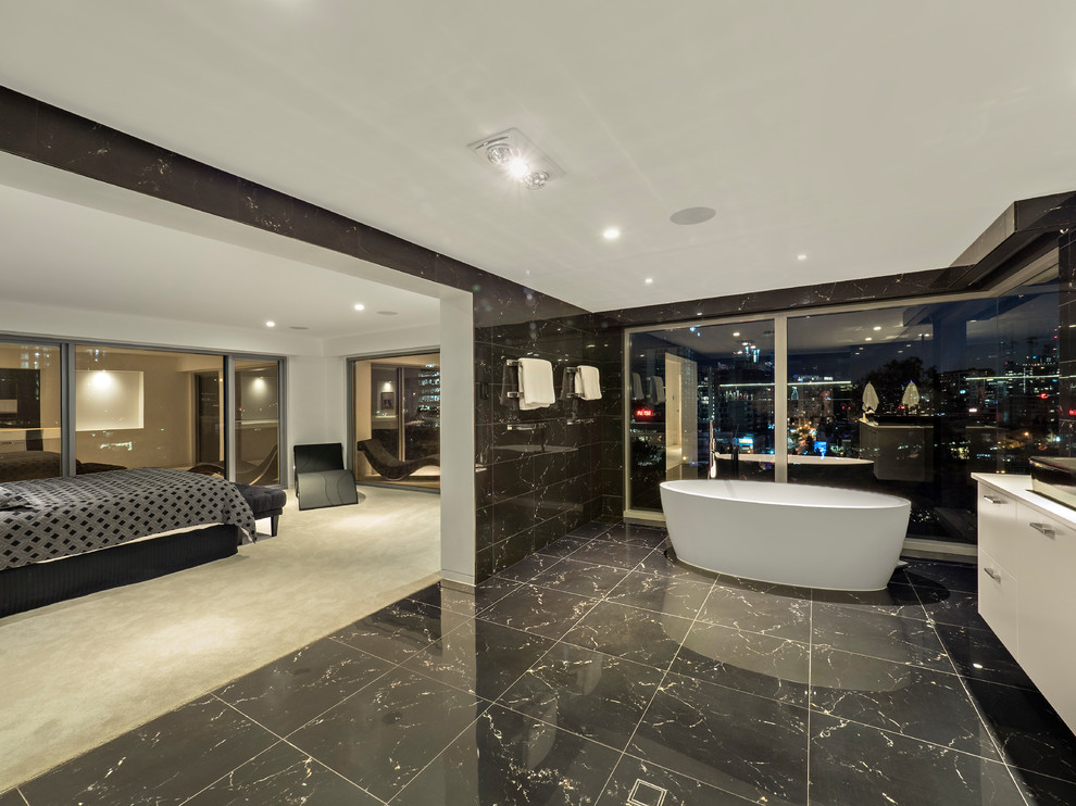 Contemporary bathroom in Brisbane with flat-panel cabinets, white cabinets, a freestanding bath, a vessel sink, white worktops, black tiles, black walls and black floors.