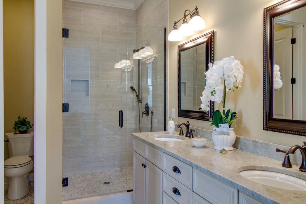アトランタにあるトラディショナルスタイルのおしゃれな浴室 (コーナー設置型シャワー、ベージュのタイル、セラミックタイル、ベージュの壁、セラミックタイルの床、アンダーカウンター洗面器、珪岩の洗面台、ベージュのカウンター) の写真