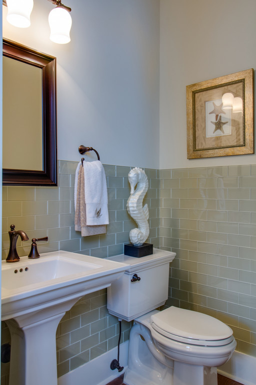 Example of a small classic 3/4 beige tile and glass tile medium tone wood floor and brown floor bathroom design in Other with beige walls and a pedestal sink