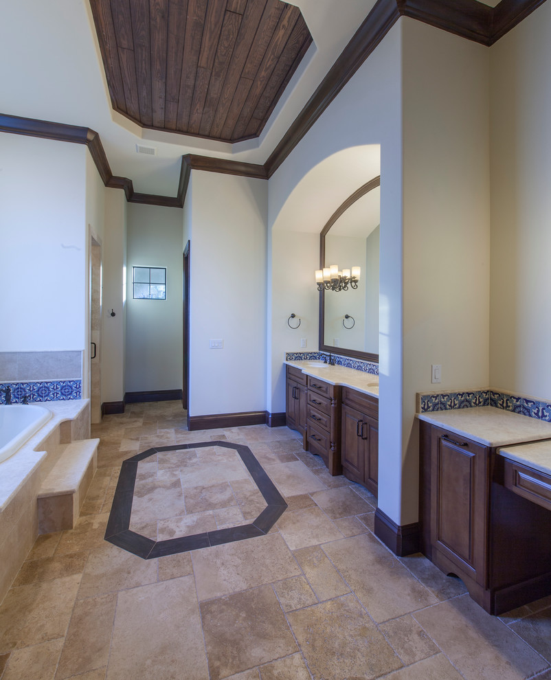 Inspiration for a huge mediterranean master blue tile and ceramic tile travertine floor bathroom remodel in Orlando with raised-panel cabinets, dark wood cabinets, a one-piece toilet, beige walls, a drop-in sink and granite countertops