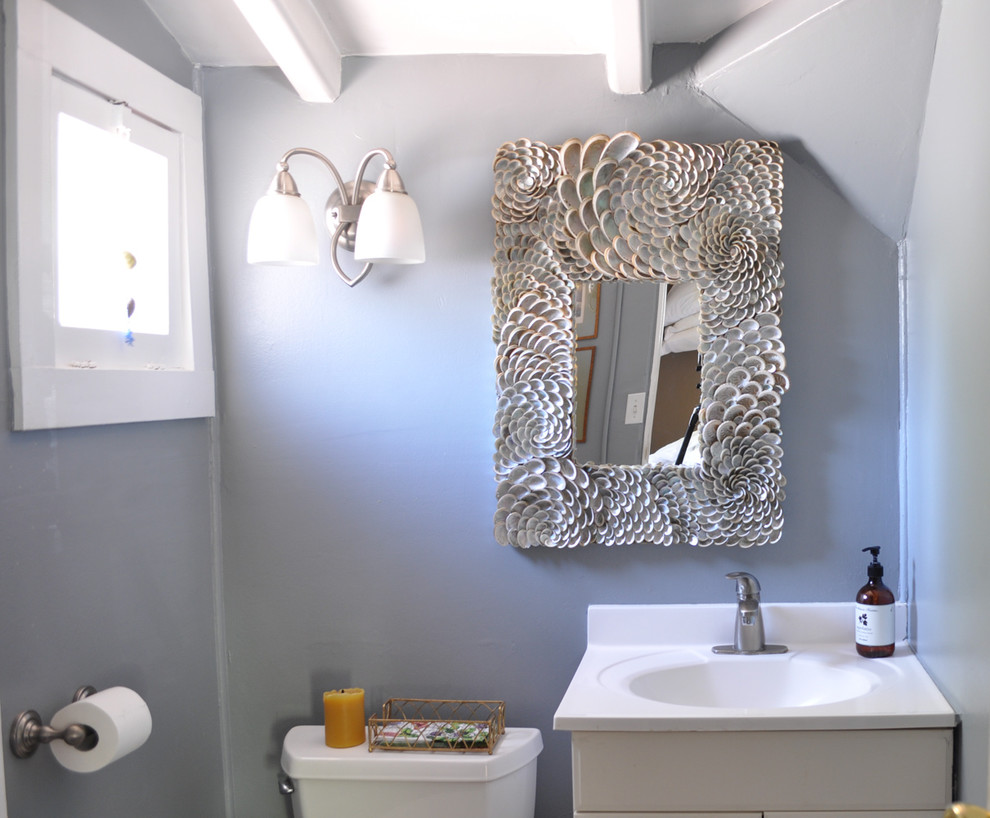 Imagen de cuarto de baño mediterráneo con lavabo tipo consola, armarios con paneles empotrados, puertas de armario blancas, encimera de acrílico, sanitario de una pieza, paredes grises y suelo de baldosas de porcelana