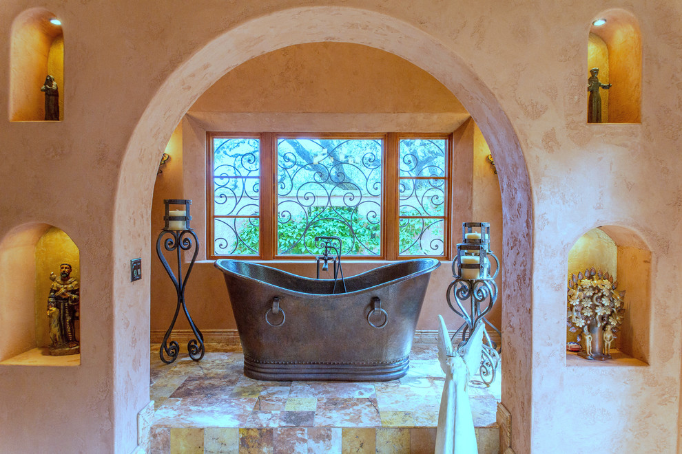 Medium sized ensuite bathroom in Austin with a freestanding bath, stone tiles, beige walls and travertine flooring.