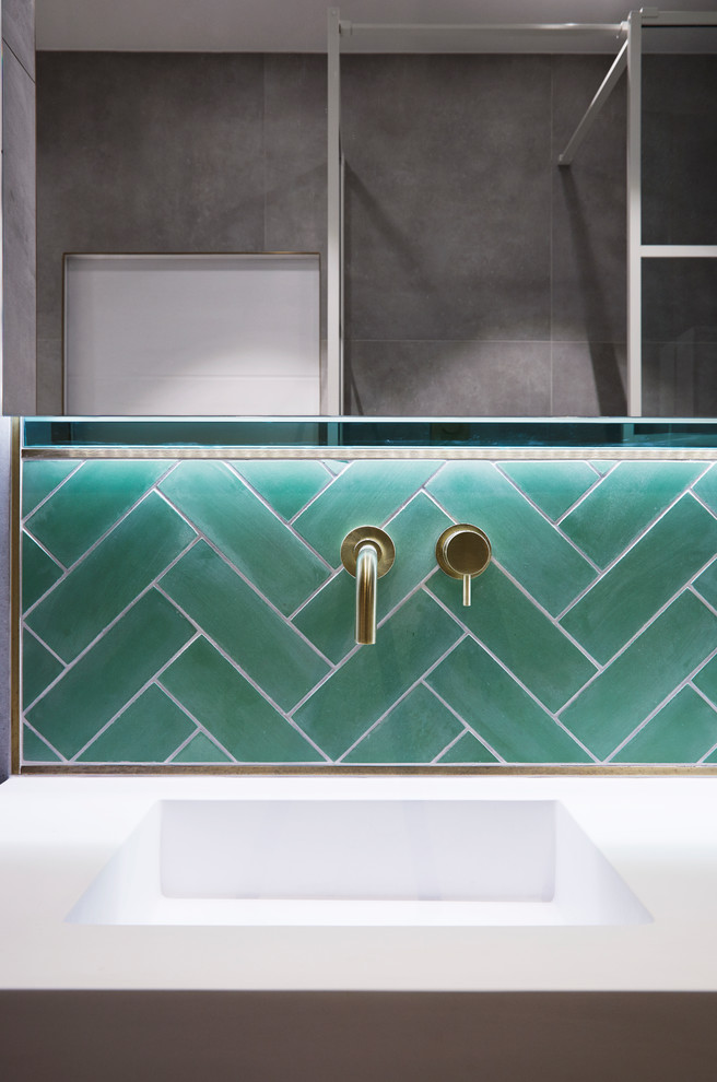 This is an example of a contemporary bathroom in London with green tiles and grey walls.