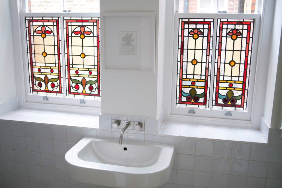 This is an example of a medium sized contemporary bathroom in London with glass-front cabinets.