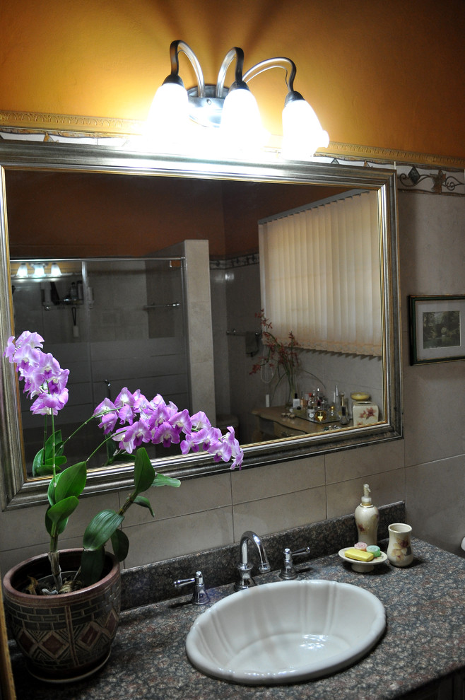 Пример оригинального дизайна: главная ванная комната среднего размера в стиле неоклассика (современная классика) с фасадами с утопленной филенкой, светлыми деревянными фасадами, душевой комнатой, раздельным унитазом, бежевой плиткой, цементной плиткой, оранжевыми стенами, полом из керамогранита, накладной раковиной, столешницей из гранита, бежевым полом и душем с распашными дверями