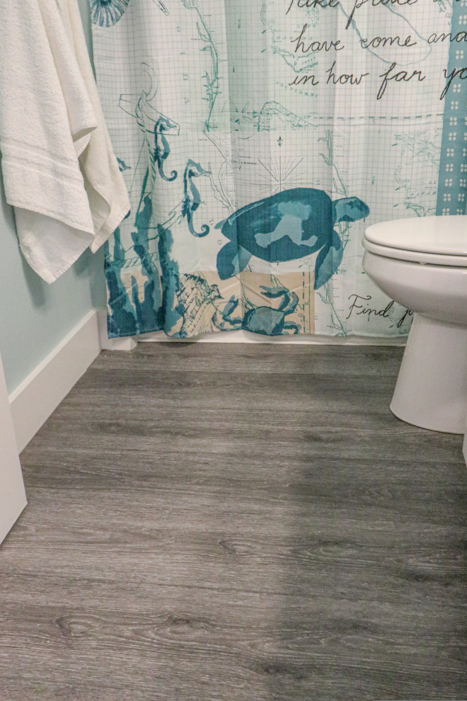 Ispirazione per una piccola stanza da bagno con doccia stile marinaro con vasca/doccia, pavimento in vinile e pavimento grigio