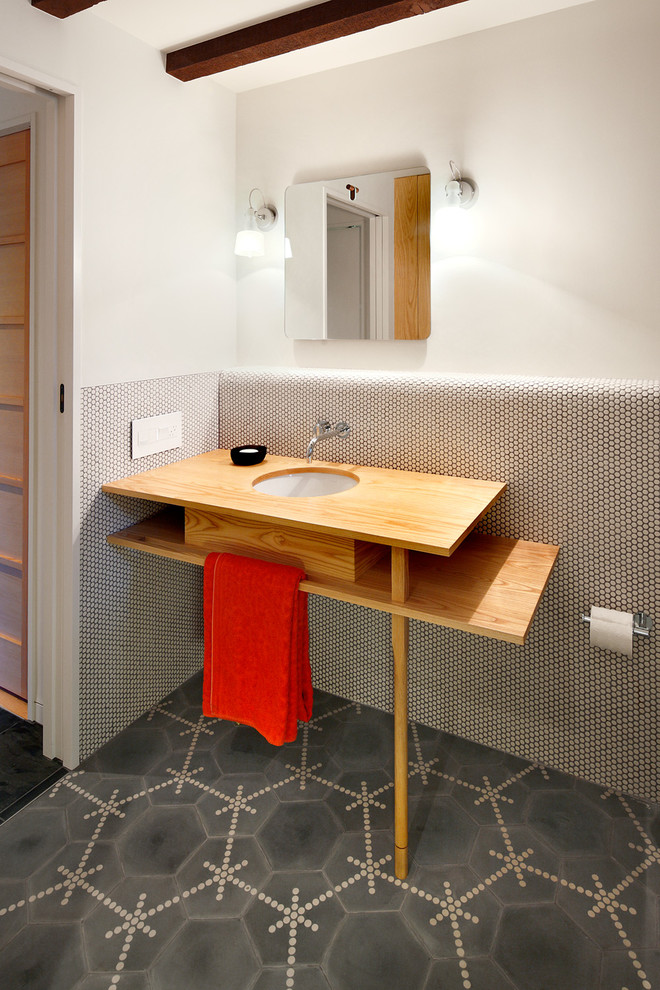 На фото: ванная комната в современном стиле с накладной ванной, душем над ванной, унитазом-моноблоком, белыми стенами, полом из керамогранита, столешницей из дерева и серым полом
