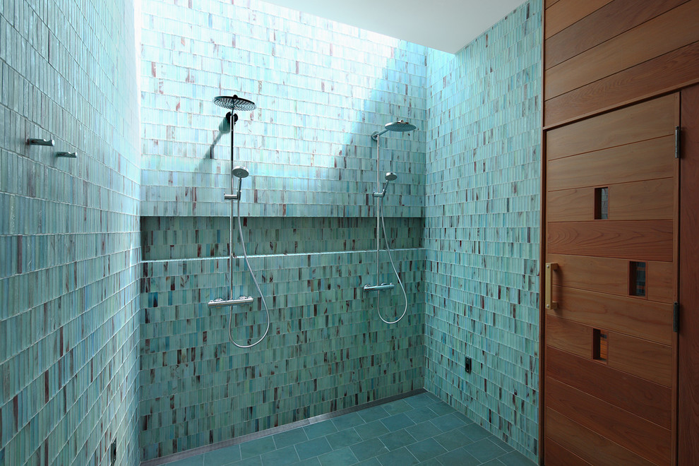 Exemple d'une grande salle de bain principale tendance avec une douche double, un carrelage bleu, un mur bleu, un carrelage en pâte de verre, un sol en carrelage de porcelaine, un sol gris et une niche.