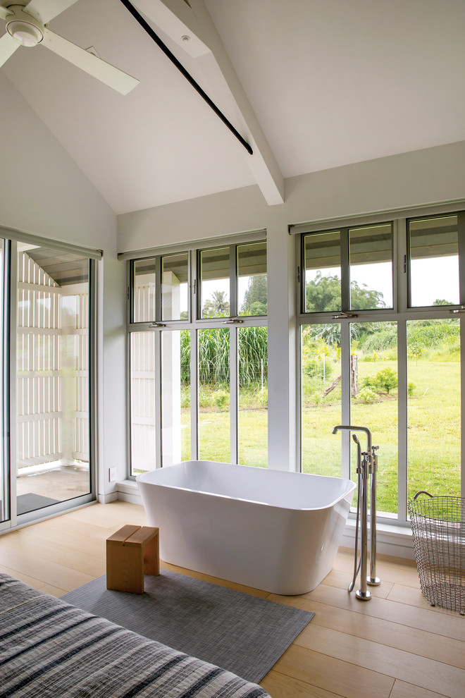 Idéer för att renovera ett lantligt badrum, med ett fristående badkar, vita väggar, ljust trägolv och beiget golv