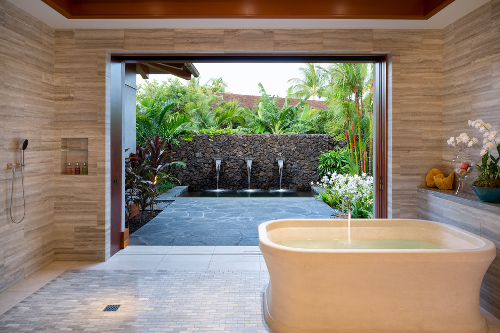 Réalisation d'une salle de bain principale ethnique avec une baignoire indépendante, une douche ouverte, un carrelage gris, un carrelage de pierre, un mur beige et aucune cabine.