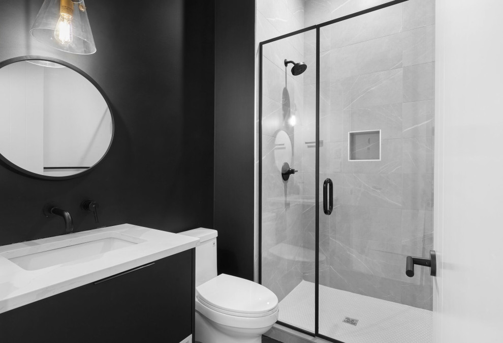 Стильный дизайн: ванная комната в современном стиле с плоскими фасадами, черными фасадами, серой плиткой, керамогранитной плиткой, черными стенами, врезной раковиной, столешницей из искусственного кварца, белой столешницей, душем в нише, раздельным унитазом, душевой кабиной, душем с распашными дверями, нишей и тумбой под одну раковину - последний тренд