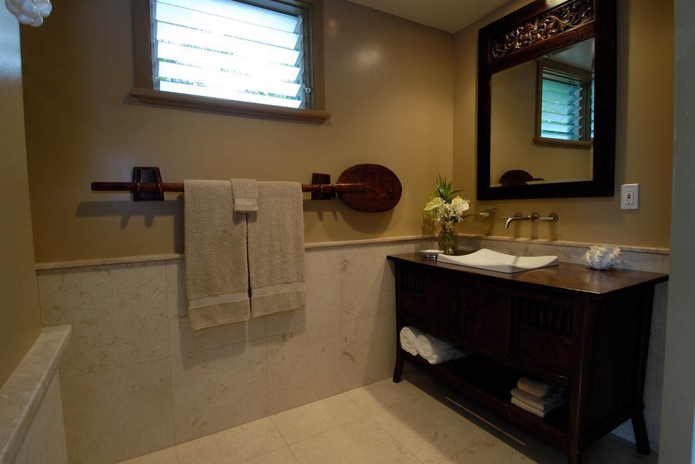 Ejemplo de cuarto de baño tropical con lavabo sobreencimera y piedra