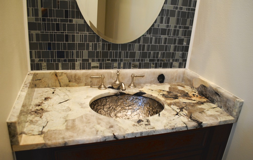 This is an example of a small bohemian bathroom in New Orleans with a submerged sink, raised-panel cabinets, dark wood cabinets, granite worktops, a two-piece toilet, grey tiles, glass tiles, beige walls and marble flooring.