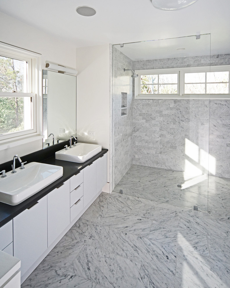 Foto på ett mellanstort funkis en-suite badrum, med släta luckor, vita skåp, en dusch i en alkov, grå kakel, vit kakel, tunnelbanekakel, vita väggar, marmorgolv, ett fristående handfat och bänkskiva i akrylsten