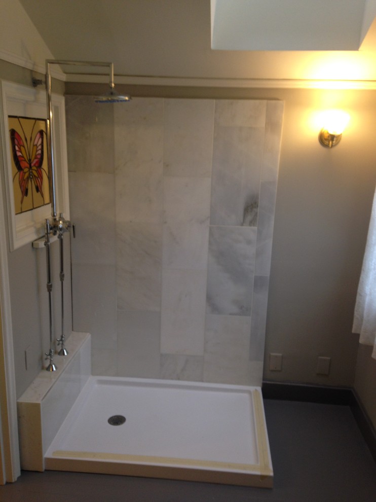 Klassisk inredning av ett mellanstort badrum, med grå skåp, en öppen dusch, en toalettstol med separat cisternkåpa, vit kakel, stenkakel, beige väggar, målat trägolv, ett fristående handfat och träbänkskiva