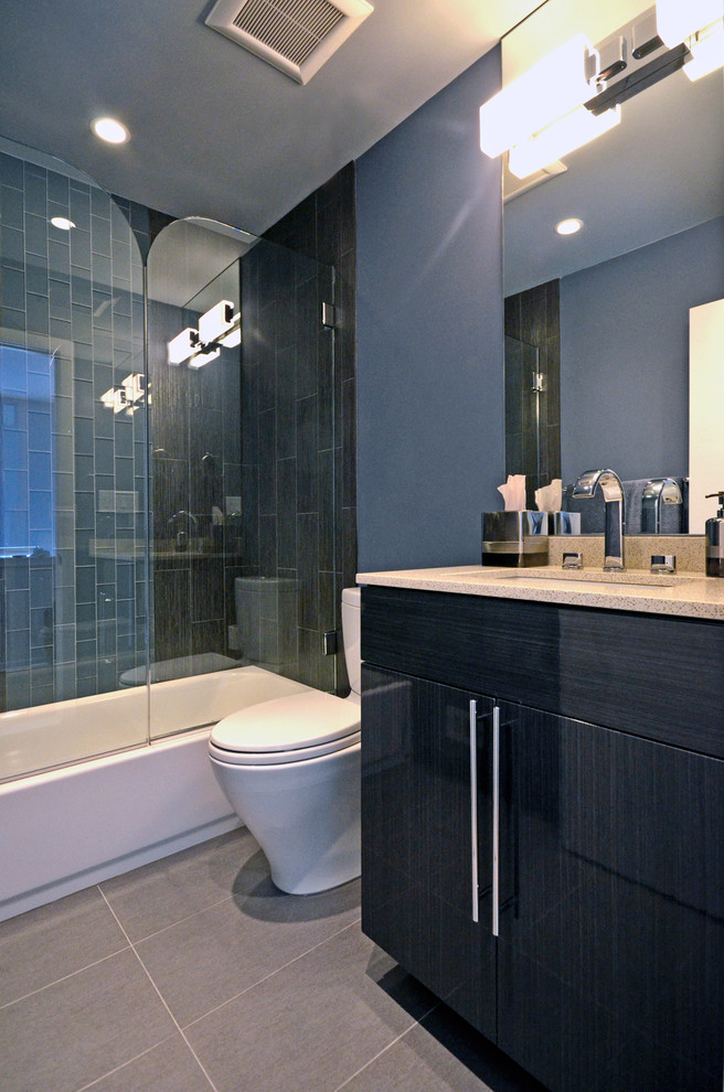 Inspiration för mellanstora moderna badrum med dusch, med släta luckor, svarta skåp, bänkskiva i kvartsit, porslinskakel, en toalettstol med hel cisternkåpa, klinkergolv i porslin och grå väggar