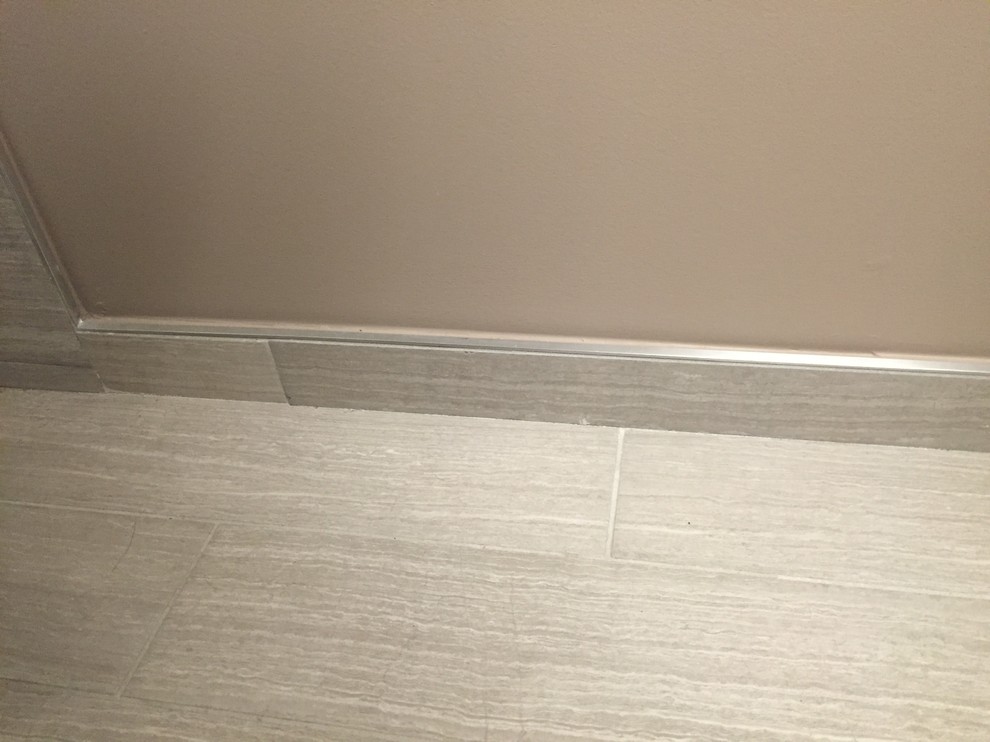 Cette photo montre une petite douche en alcôve moderne pour enfant avec un placard à porte shaker, des portes de placard grises, WC séparés, un carrelage gris, des carreaux de porcelaine, un sol en carrelage de porcelaine, un lavabo intégré et un plan de toilette en surface solide.