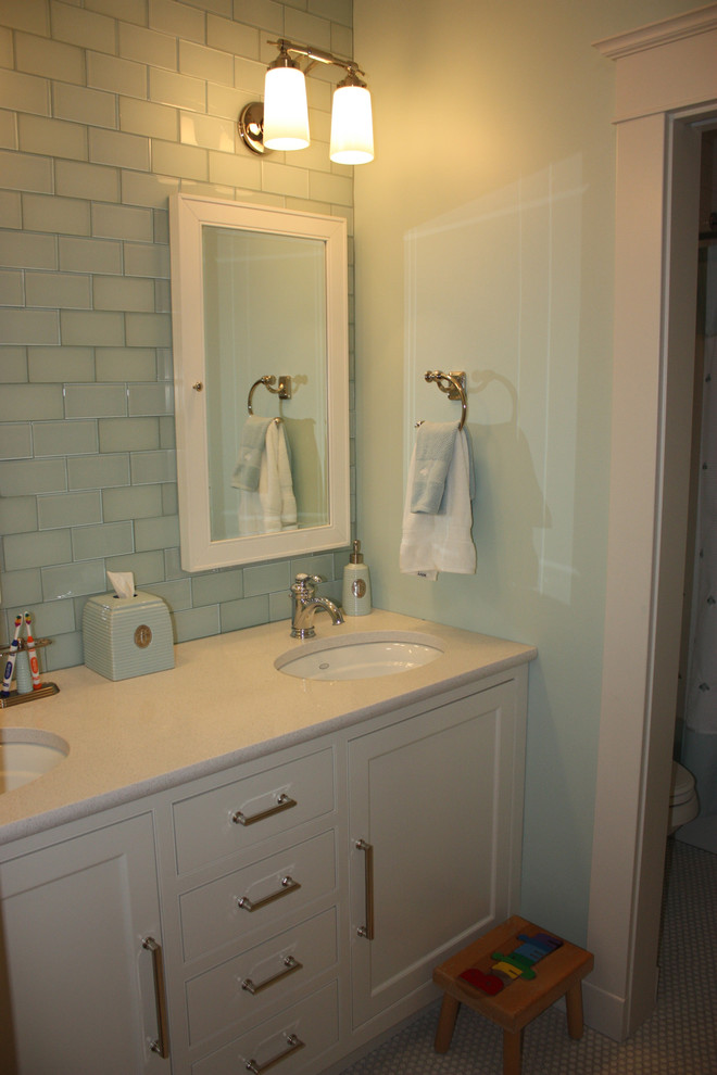 Foto på ett funkis badrum för barn, med vita skåp, ett undermonterad handfat, blå kakel, glaskakel och blå väggar