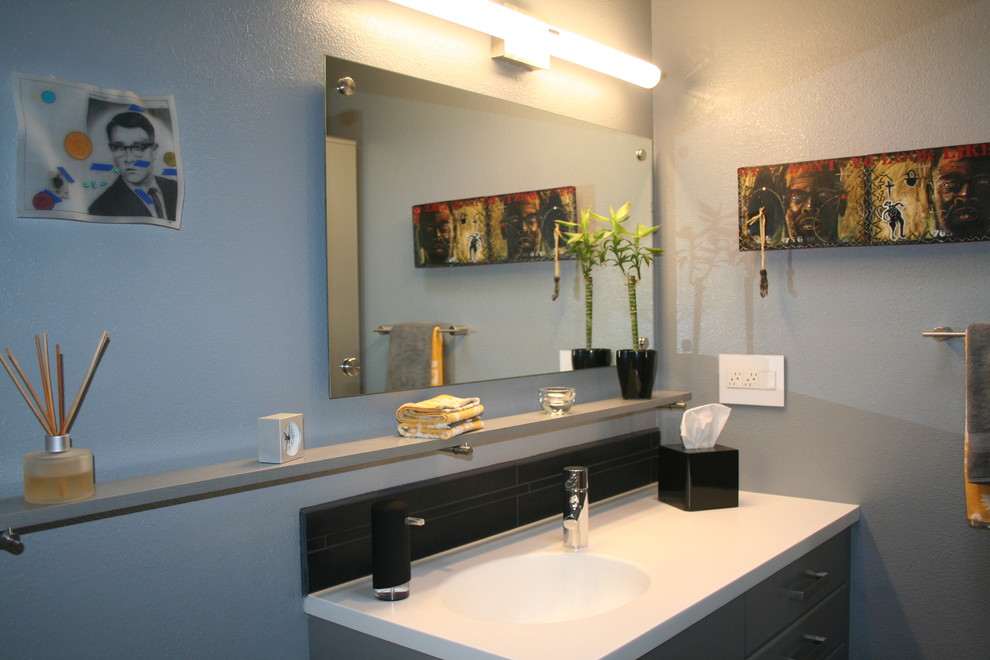 Immagine di una piccola stanza da bagno con doccia design con lavabo integrato, ante lisce, ante grigie, top in superficie solida, piastrelle nere, piastrelle in ceramica e pareti grigie